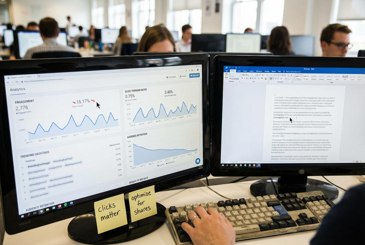 Dual monitors showing web analytics dashboards.